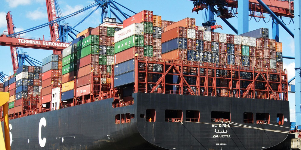 Ausschnitt eines großen Containerschiffes im Hafen bei dem die Ladung gelöscht wird.